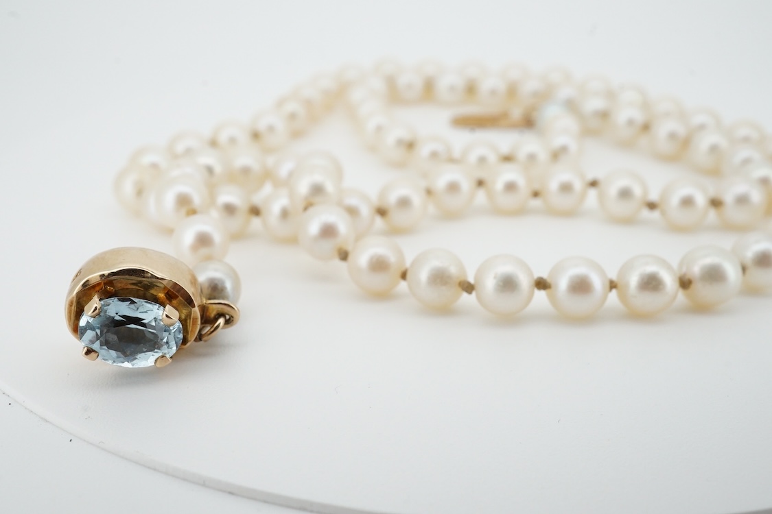 A cultured pearl and aquamarine necklace, composed of a single strand of cultured pearls, to a gold clasp set with an oval aquamarine, length 53.5cm, Condition: in good condition, minor wear, minor variations in pearl co